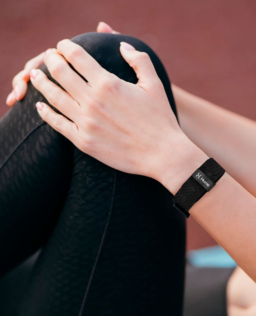 Close-up of hands with the Hume Health Band on the wrist during a stretching routine